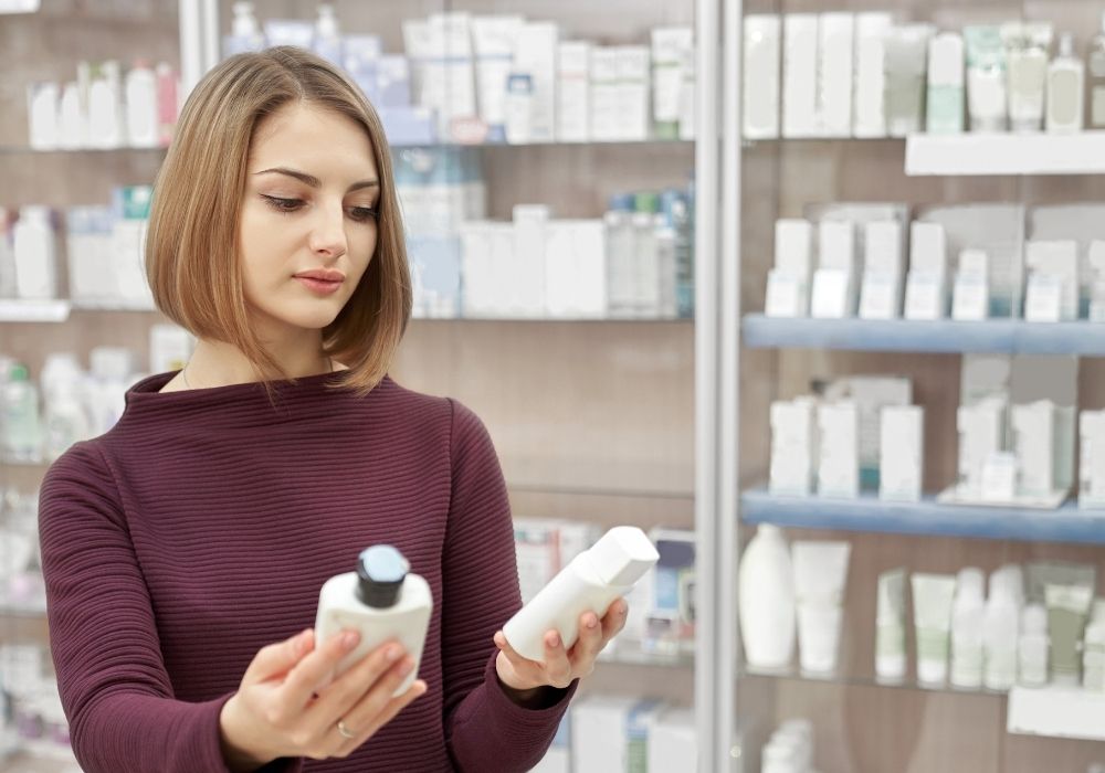 Frau in Drogerie wählt aus 2 Produkten